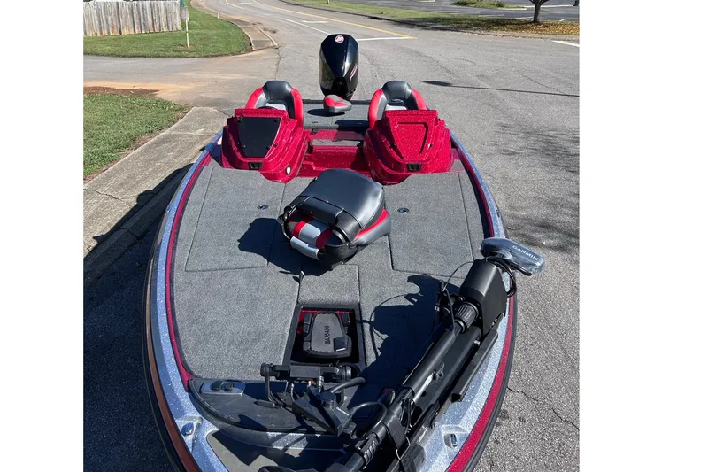 Slide: The Image of 2027 Nitro Z19 XL Pro bass boat with red accents, parked on a street. - 3