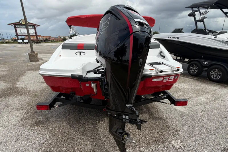 Slide: The Image of 2027 Tahoe T18 boat with outboard motor, parked outdoors near Outdoor World. - 5