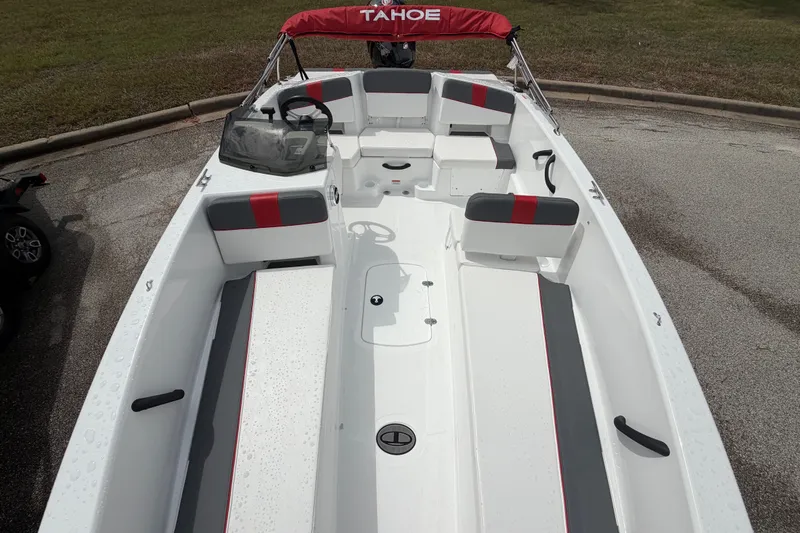 Slide: The Image of 2027 Tahoe T18 boat with red and gray seating, parked on pavement. - 9