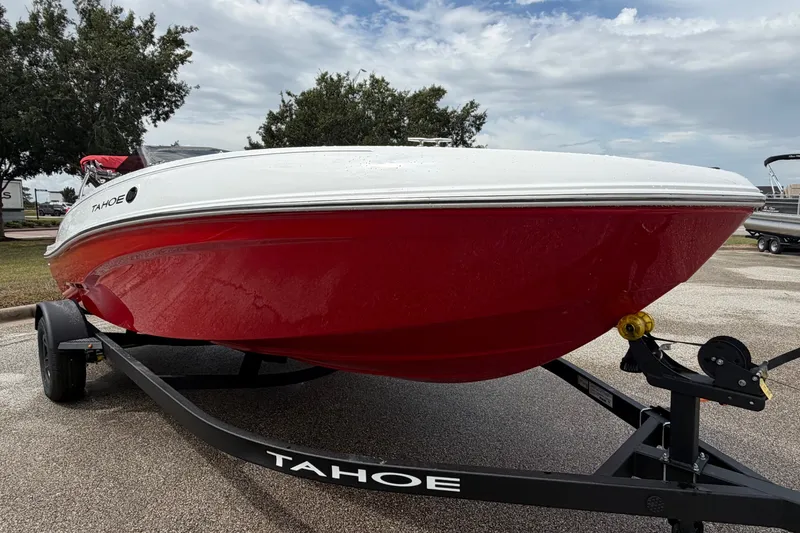 Slide: The Image of 2027 Tahoe T18 boat with red hull on trailer under cloudy sky. - 7