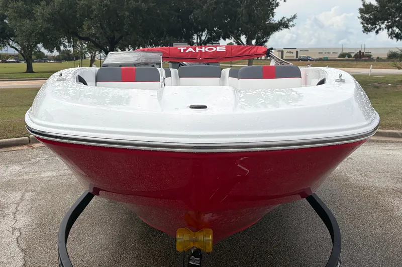 Slide: The Image of 2027 Tahoe T18 boat with red and white design, parked outdoors on a cloudy day. - 2