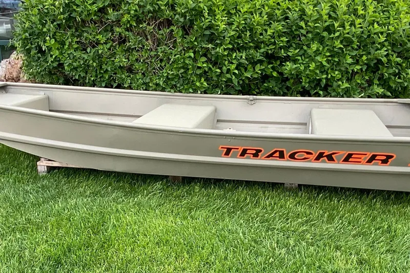 The Image of 2027 Tracker Grizzly 12 Jon boat on grass, featuring bold orange branding. - 0