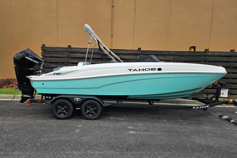 The Image of 2027 Tahoe T21 boat on trailer, turquoise hull, parked outdoors. - 0