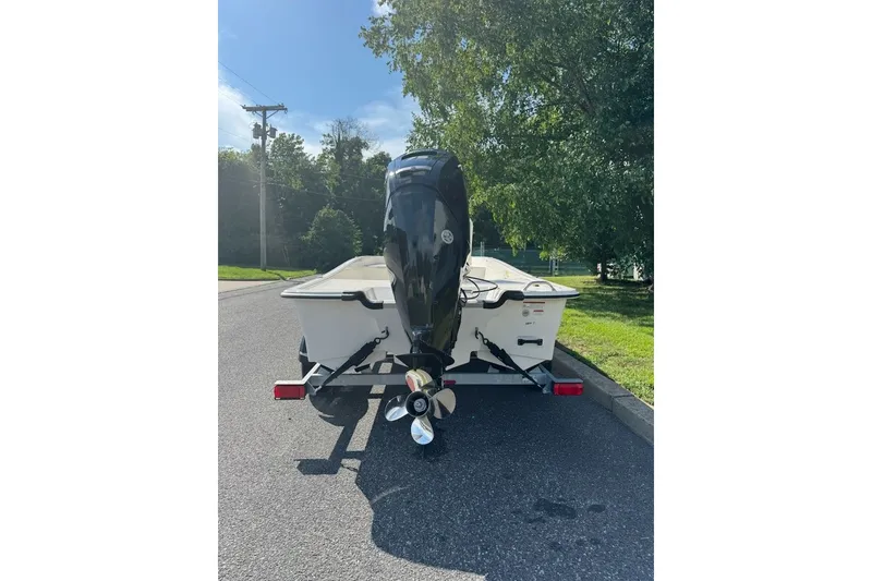 Slide: The Image of 2027 Mako Pro Skiff 17 CC boat on trailer, parked on a sunny street. - 3