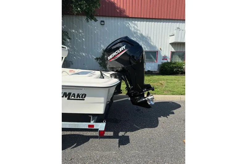 Slide: The Image of 2027 Mako Pro Skiff 17 CC with Mercury outboard motor, parked outdoors. - 5