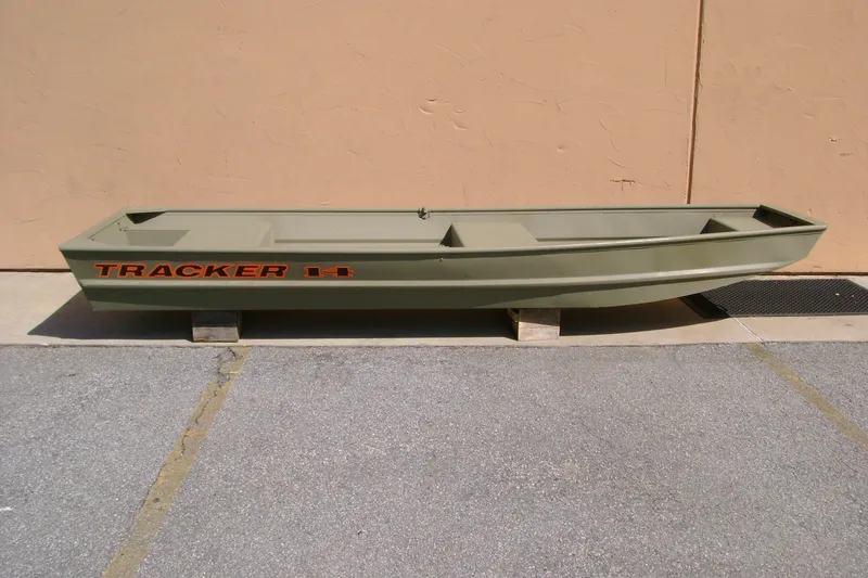 The Image of 2027 Tracker Grizzly 14 Jon boat displayed outdoors on wooden blocks. - 0