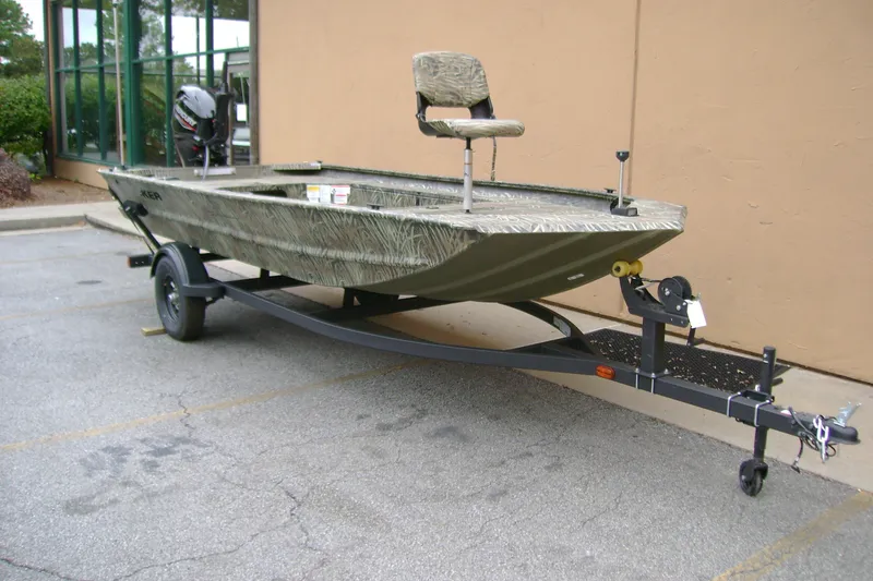 The Image of 2027 Tracker Grizzly 1654 T Sportsman boat on trailer, parked outdoors. - 0