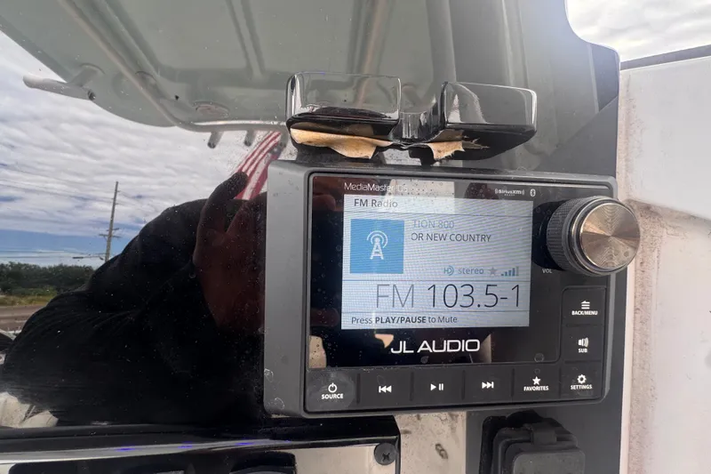 Slide: The Image of JL Audio system on 2024 Sea Hunt Escape 25 displaying FM radio station 103.5-1. - 27