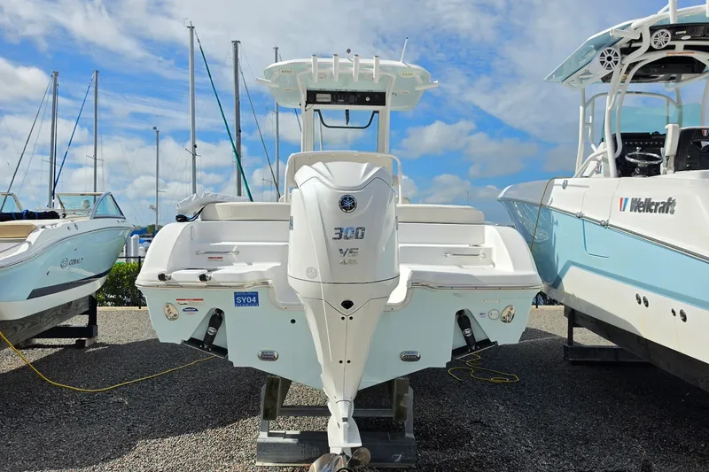Slide: The Image of 2024 Sea Hunt Escape 25 boat with Yamaha 300 engine, docked between other boats. - 3
