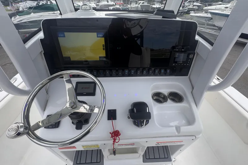 Slide: The Image of 2024 Sea Hunt Escape 25 boat dashboard with steering wheel and navigation display. - 25