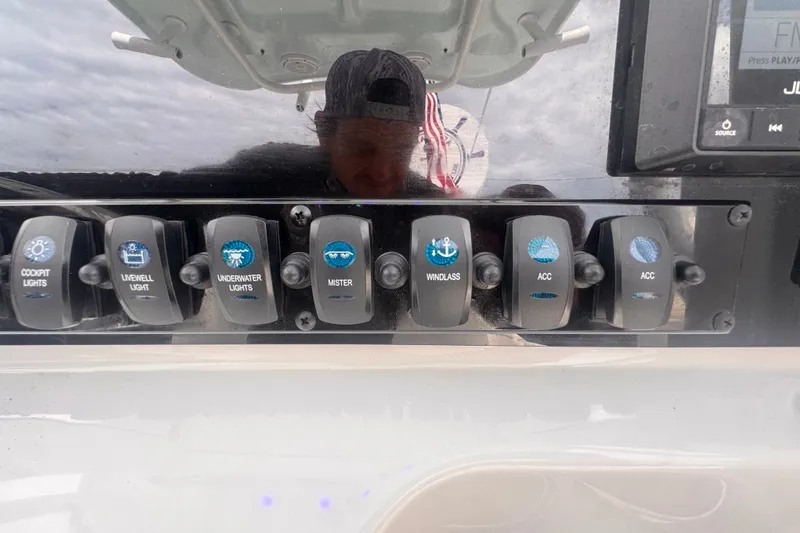 Slide: The Image of Control panel of 2024 Sea Hunt Escape 25 boat with various switches. - 34