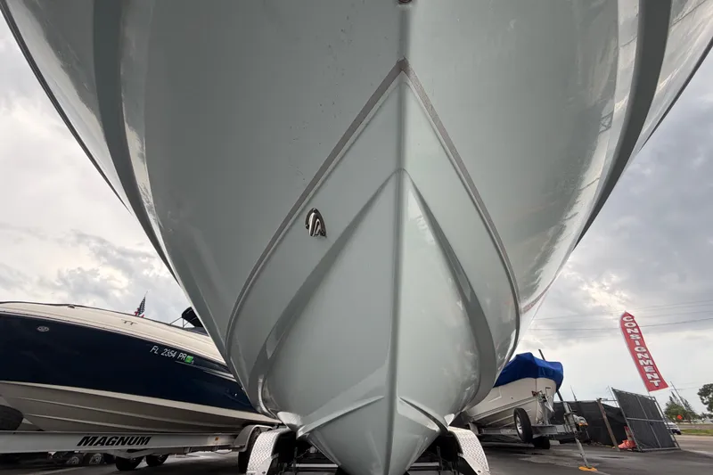 Slide: The Image of 2024 Sea Hunt Escape 25 boat hull, displayed outdoors with other boats. - 5