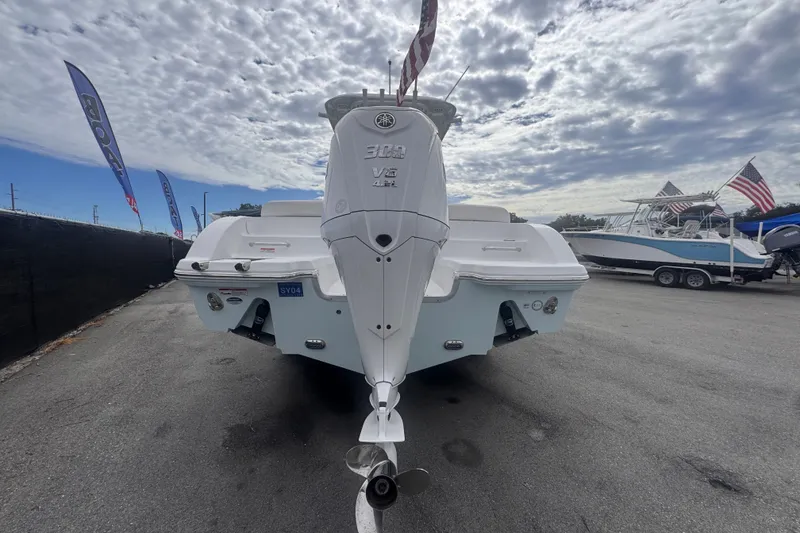 Slide: The Image of 2024 Sea Hunt Escape 25 boat with powerful outboard motor, displayed outdoors under cloudy sky. - 4