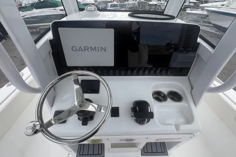 Slide: The Image of 2024 Sea Hunt Escape 25 boat dashboard with Garmin navigation system and steering wheel. - 24