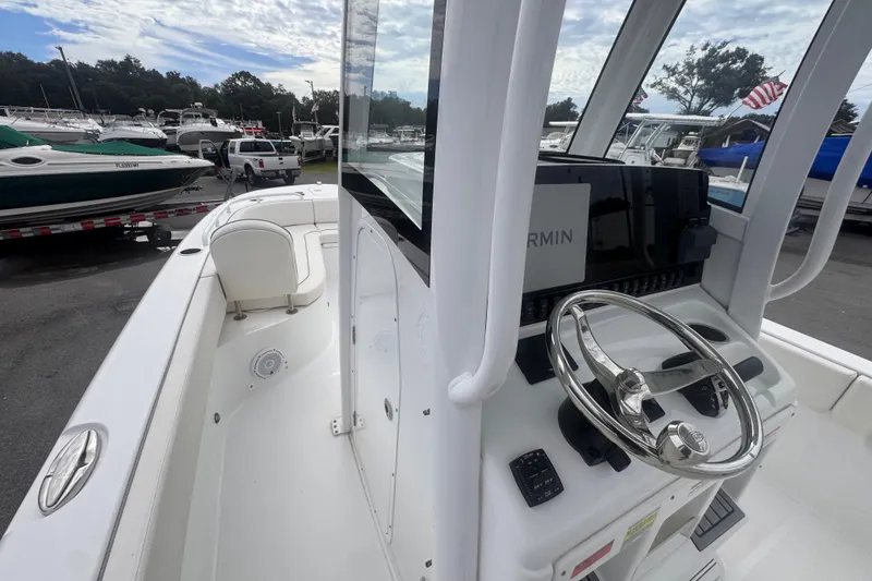 Slide: The Image of 2024 Sea Hunt Escape 25 boat interior with steering wheel and Garmin navigation system. - 23