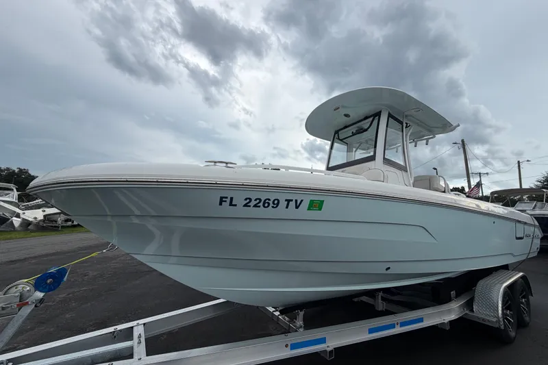 Slide: The Image of 2024 Sea Hunt Escape 25 boat on trailer under cloudy sky. - 1