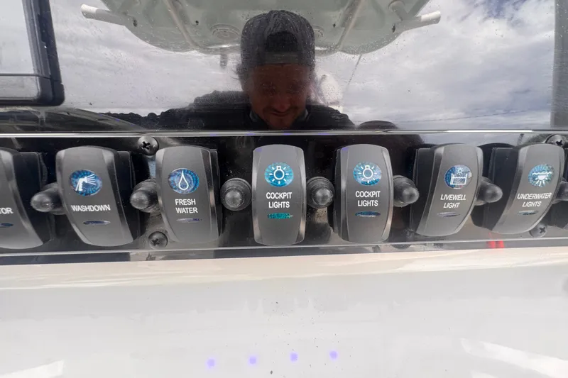 Slide: The Image of Control panel of 2024 Sea Hunt Escape 25 boat with various switches. - 33