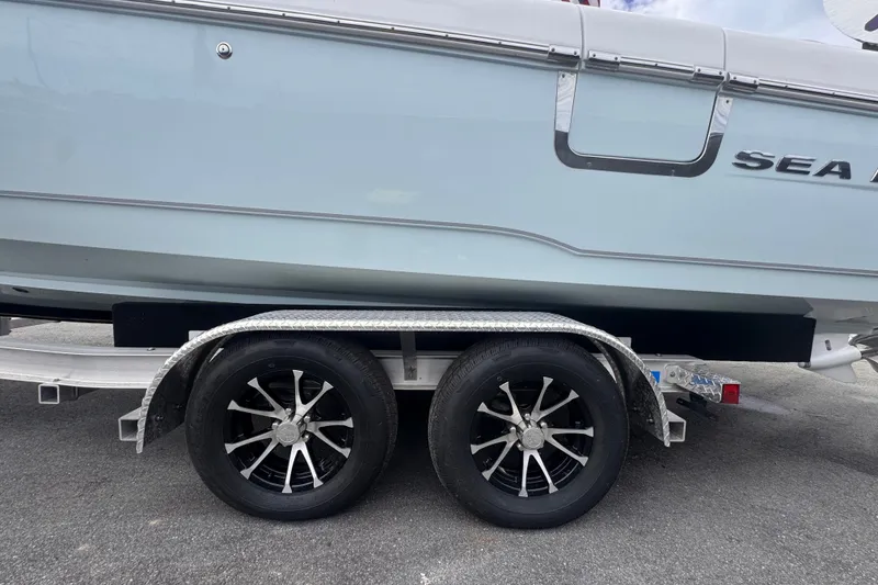 Slide: The Image of 2024 Sea Hunt Escape 25 boat on trailer with dual black alloy wheels. - 72