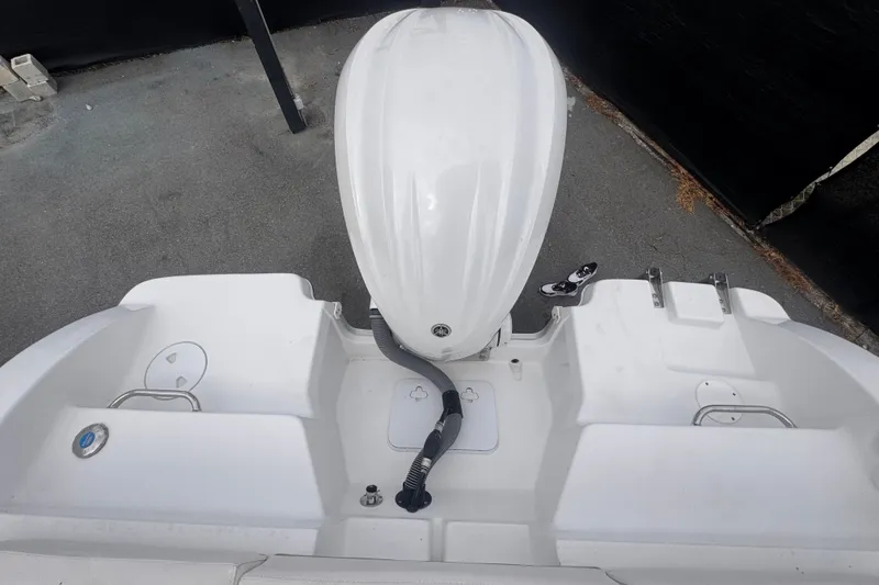 Slide: The Image of 2024 Sea Hunt Escape 25 boat stern with outboard motor, white deck, and storage compartments. - 68
