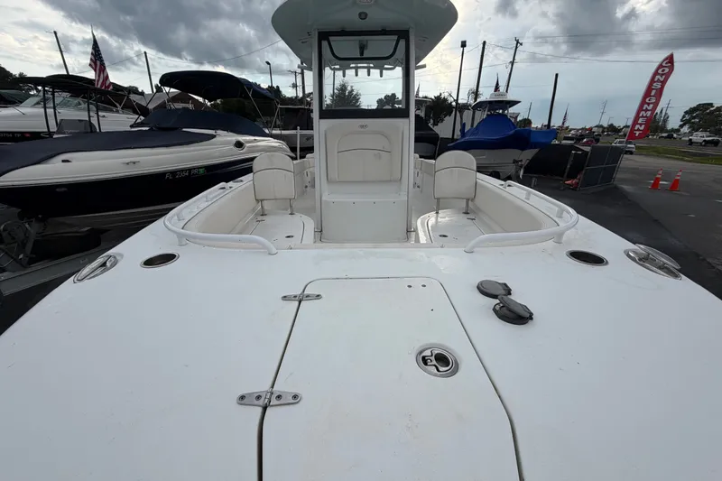 Slide: The Image of 2024 Sea Hunt Escape 25 boat, spacious deck, docked with other boats, overcast sky. - 9