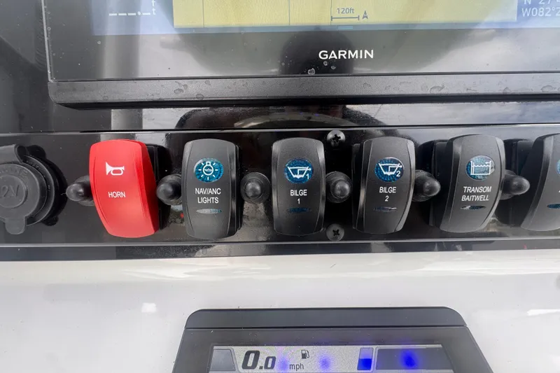 Slide: The Image of Control panel of a 2024 Sea Hunt Escape 25 boat with various switches. - 31