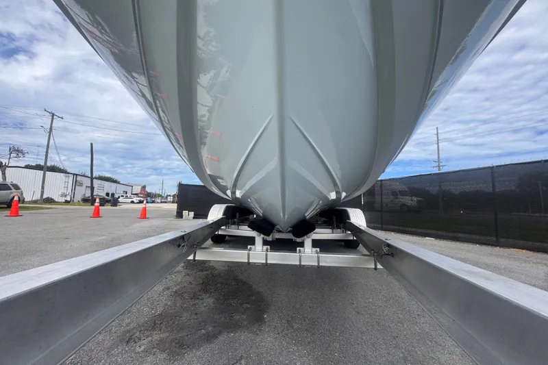 Slide: The Image of 2024 Sea Hunt Escape 25 boat on trailer, viewed from below, in a parking area. - 16