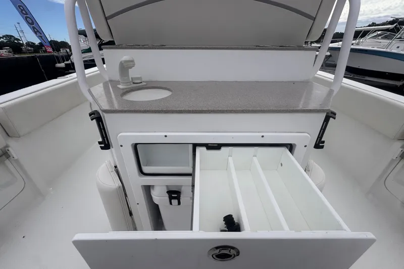 Slide: The Image of 2024 Sea Hunt Escape 25 boat interior with sink and storage compartments. - 19