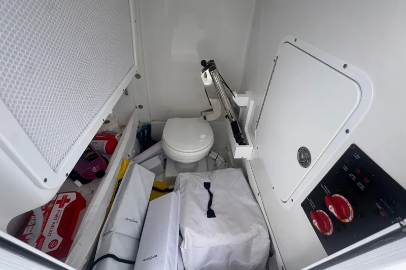Slide: The Image of 2024 Sea Hunt Escape 25 boat interior with toilet, storage, and control panel. - 46