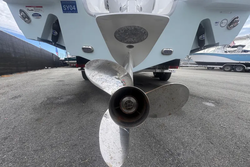 Slide: The Image of 2024 Sea Hunt Escape 25 boat propeller close-up in a marina setting. - 7