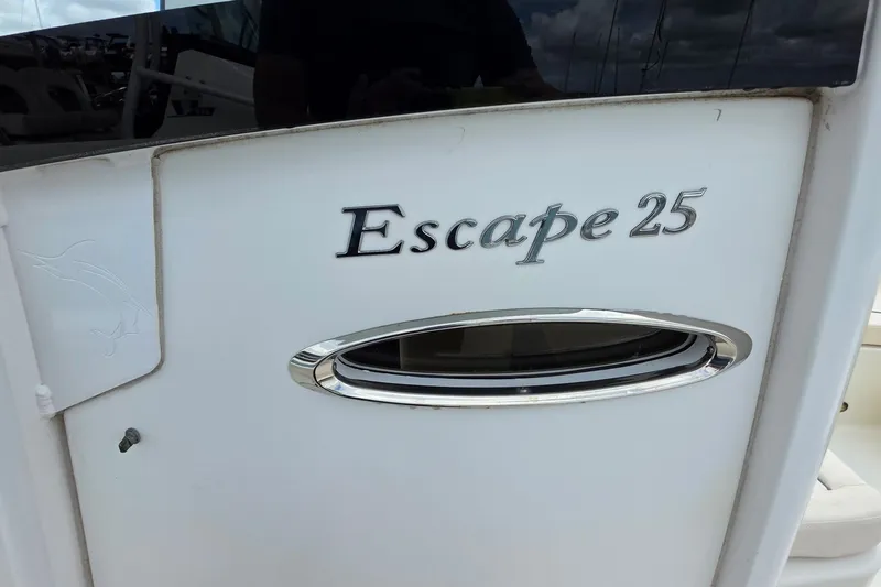 Slide: The Image of 2024 Sea Hunt Escape 25 boat exterior with logo and sleek design details. - 9