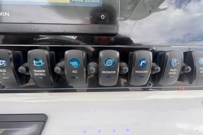 Slide: The Image of Control panel of 2024 Sea Hunt Escape 25 boat with labeled switches. - 32