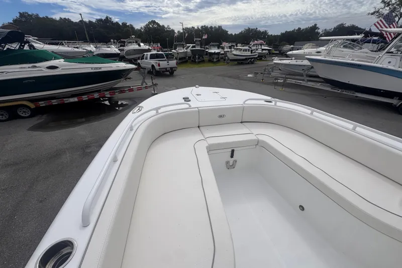 Slide: The Image of 2024 Sea Hunt Escape 25 boat with spacious seating, parked among other boats. - 49