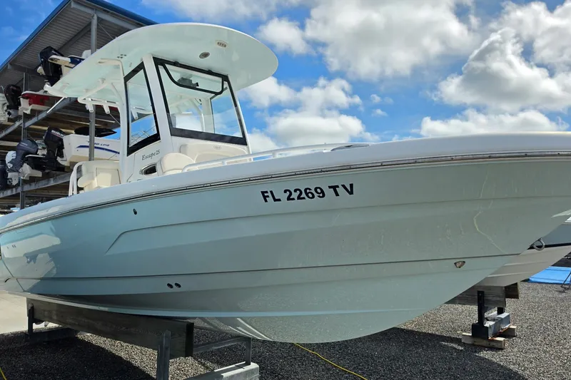 Slide: The Image of 2024 Sea Hunt Escape 25 boat on display under a blue sky. - 1