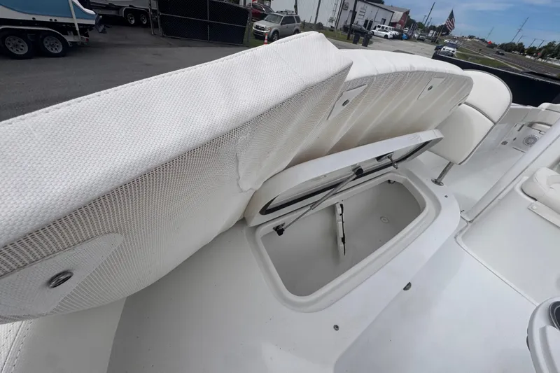 Slide: The Image of 2024 Sea Hunt Escape 25 boat with open storage compartment and white seating. - 56