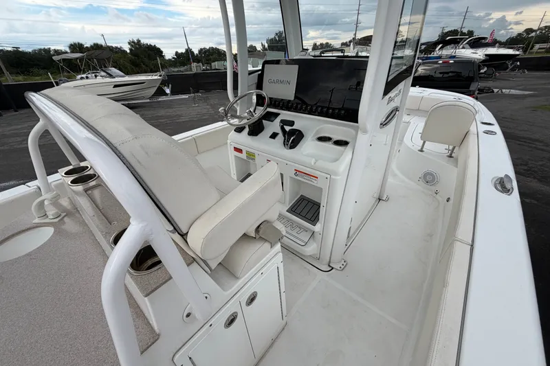 Slide: The Image of 2024 Sea Hunt Escape 25 boat interior with helm, seating, and Garmin navigation system. - 7