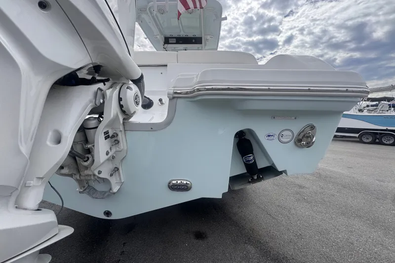 Slide: The Image of 2024 Sea Hunt Escape 25 boat stern view with outboard motor and cloudy sky. - 3