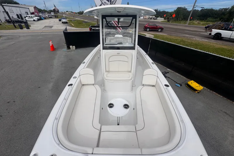 Slide: The Image of 2024 Sea Hunt Escape 25 boat with spacious seating and sleek design, parked outdoors. - 58