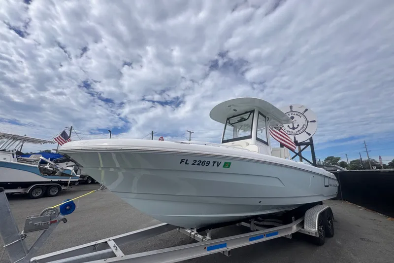 Slide: The Image of 2024 Sea Hunt Escape 25 boat on trailer under cloudy sky. - 11