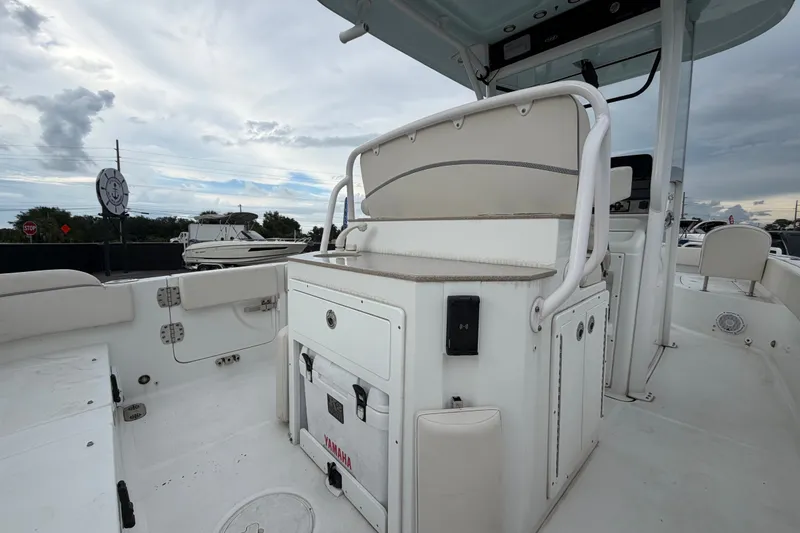 Slide: The Image of 2024 Sea Hunt Escape 25 boat interior with seating and storage, under a cloudy sky. - 6