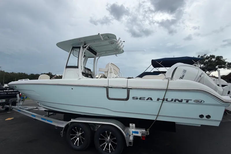 Slide: The Image of 2024 Sea Hunt Escape 25 boat on trailer under cloudy sky. - 3