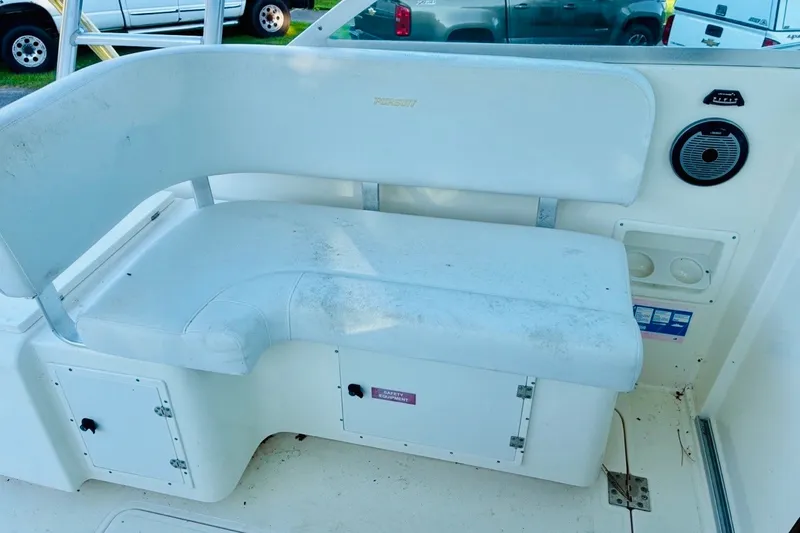 Slide: The Image of White seating area on a 2002 Pursuit 3000 Express boat, featuring storage compartments. - 27