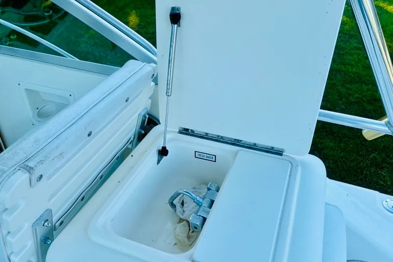 Slide: The Image of Open storage compartment on 2002 Pursuit 3000 Express boat, featuring fresh water access. - 60