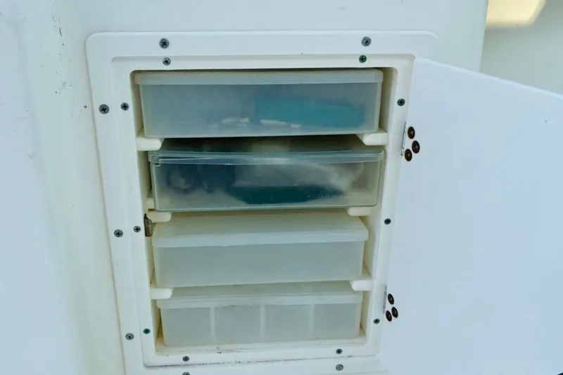 Slide: The Image of Storage compartment with plastic drawers on a 2002 Pursuit 3000 Express boat. - 33