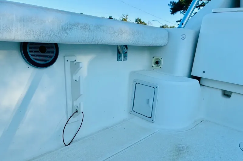 Slide: The Image of 2002 Pursuit 3000 Express boat interior detail with storage compartment and speaker. - 76