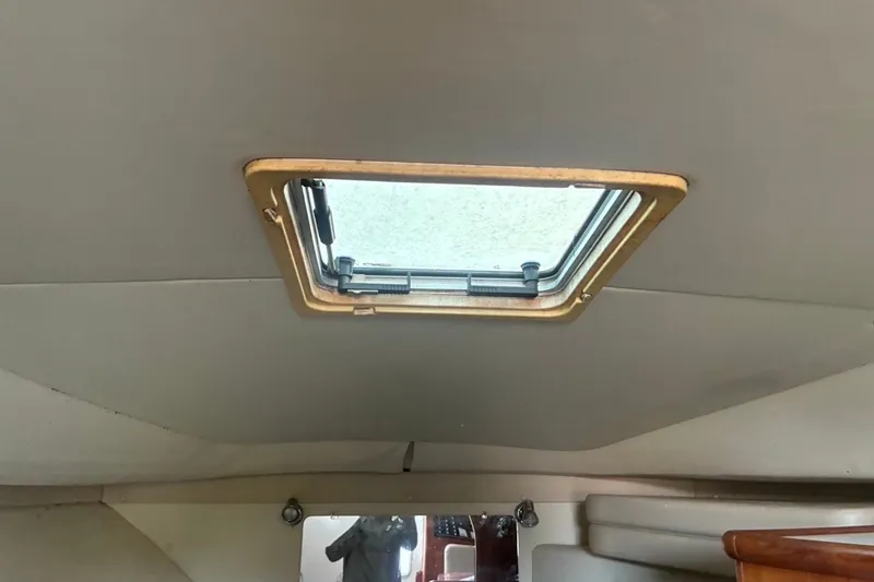 Slide: The Image of Interior cabin view of a 2002 Pursuit 3000 Express boat with a ceiling hatch. - 48