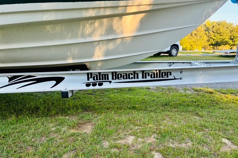 Slide: The Image of 2002 Pursuit 3000 Express boat on Palm Beach Trailer, parked on grass. - 91