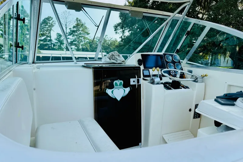 Slide: The Image of 2002 Pursuit 3000 Express boat interior with steering console and seating area. - 8