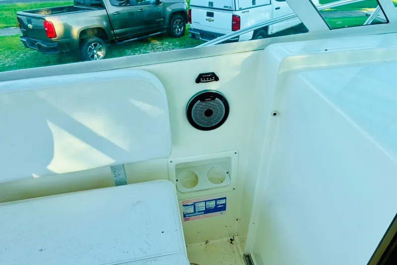 Slide: The Image of Interior of a 2002 Pursuit 3000 Express boat, featuring seating and a speaker. - 72