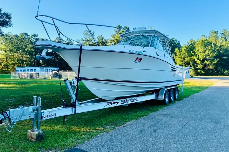 Slide: The Image of 2002 Pursuit 3000 Express boat on trailer, parked outdoors, with "For Sale" sign. - 88