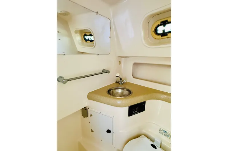 Slide: The Image of 2002 Pursuit 3000 Express boat bathroom with sink and porthole window. - 12